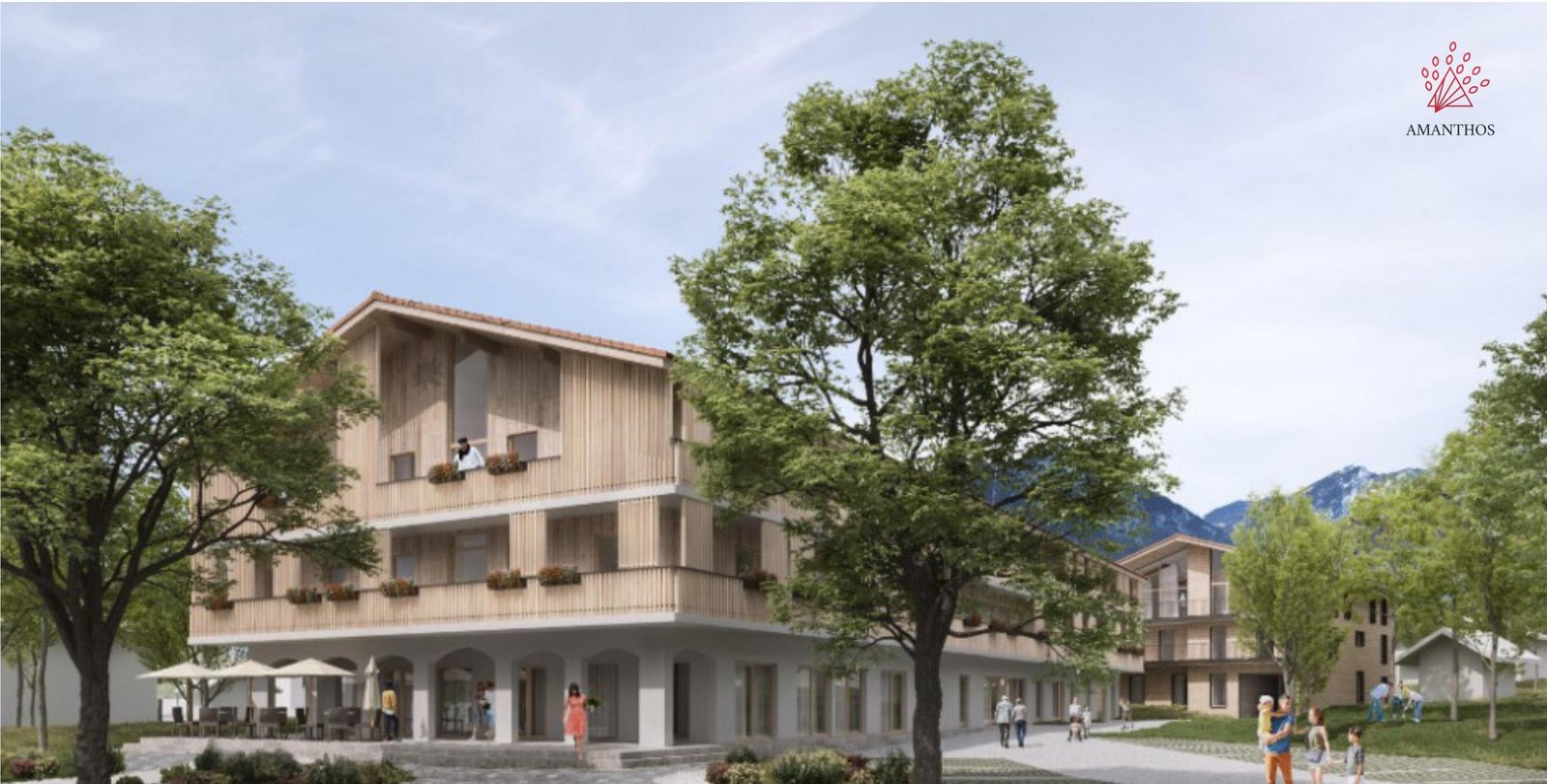 Aussenansicht des Neubaus: dreigeschossiges Haus mit Holzfassade, Balkonen und Arkadengang, umgeben von Baeumen.